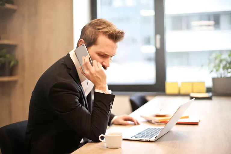Employeur au téléphone devant son ordinateur